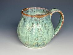 a green and brown pitcher sitting on top of a table