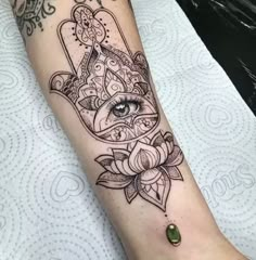 a woman's arm with a hamsah tattoo on it and an eye in the middle