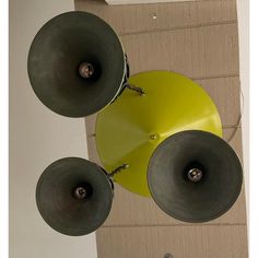 three yellow and black speakers hanging from the ceiling