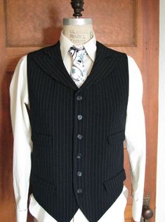 This is our latest vest style. Four pockets and wide peak lapels made for a unique look. This vest is vegan safe, cut from a stunning rayon/poly pinstripe fabric and lined in cotton with skull motifs. But you can choose from hundreds of fabrics including fine wools and silks. We can really make just about any type and style of vest that you can imagine. The matching tie and dress shirt shown in the pics are not included with this price, but we can make those also. Just contact us so we can get s Fitted Pinstripe Vest For Work, Tailored Pinstripe Business Vest, Tailored Pinstripe Vest For Business, Tailored Pinstripe Sleeveless Vest, Pinstripe Tailored Sleeveless Vest, Tailored Sleeveless Pinstripe Vest, Classic Pinstripe Vest For Formal Occasions, Classic Pinstripe Formal Vest, Fitted Striped Business Vest