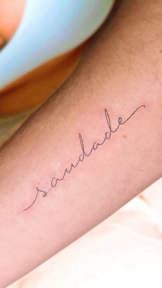 a man's arm with the word paradise written on it in cursive handwriting