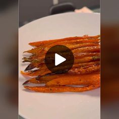 a white plate topped with cooked carrots on top of a table