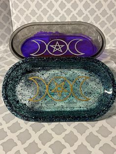 two glass trays sitting on top of a table next to each other with the moon and stars painted on them