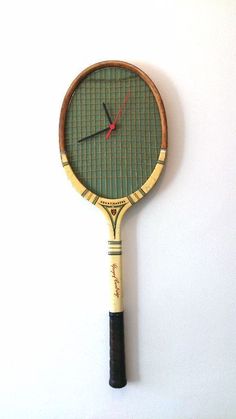 a tennis racquet mounted to the wall with a clock on it's side