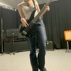 a woman standing in front of a bass guitar