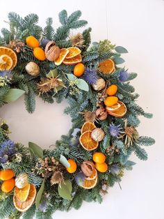 an orange and pine wreath on a white wall