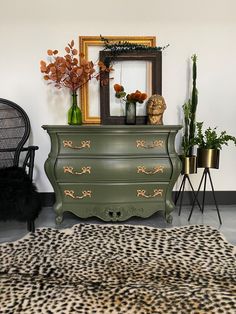 a green dresser sitting next to a black chair