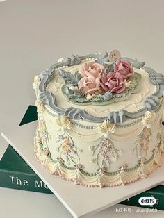 the cake is decorated with pink flowers and blue trimmings on top of it