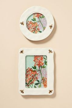 two plates with flowers painted on them sitting next to each other