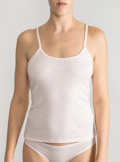 Lightweight layer in breathable organic cotton A wardrobe essential that’s perfect on its own or layered with a sweater. The camisole’s sweetly scooped neckline and slender spaghetti straps flatter décolletage and add understated elegance to the everyday. Made in North Carolina using 100% USA-grown organic cotton— the best and softest around. Wear your Lake Jane bralette under for a cool layered look! Because of the high quality of this organic fabric, you’ll get tons of wear out of your cami wi Feminine Tank Top With Built-in Bra, Layering Tank Camisole With Delicate Straps, Delicate Straps Tank Camisole For Layering, Feminine Spaghetti Strap Tank Top With Adjustable Straps, Feminine Tops With Spaghetti Straps And Built-in Bra, Feminine Seamless Cotton Camisole, Feminine Camisole Tank Top For Loungewear, Tank Camisole For Layering, Feminine Spaghetti Strap Tank Top For Loungewear