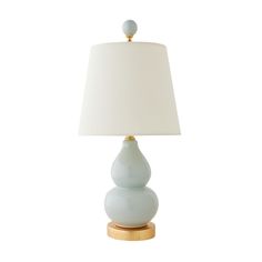 a table lamp with a white shade on it and a wooden base in front of a white background