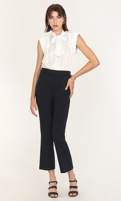 This sleeveless blouse was created for both tailored and casual looks. A modified version of the Edna Neck Tie Blouse, this high-collared piece can still be tied and styled in multiple ways. The tank top feel is comfortable and suitable for adjusting easily between formal and informal meetings. Wearing a blazer or coat over feels even easier without having to adjust sleeves to match. Tie bow blouse Sleeveless Satin Cotton Imported 100% Polyester Length: 24" Chest: 20 1/4" Hand wash in cold water Chic Stretch Blouse For Business Casual, Fitted Tie Neck Top For Workwear, Chic Tie Neck Tops For Workwear, Classic Sleeveless Bottoms For Spring, Chic Stretch Blouse For Work, Sleeveless Summer Office Tops, Sleeveless Stretch Blouse For Formal Occasions, Sleeveless Summer Top For Office Wear, Formal Sleeveless Stretch Blouse