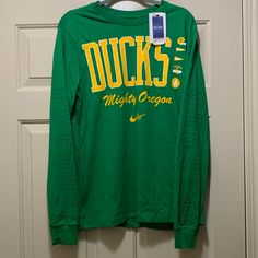 Brand New And Never Worn Nike University Of Oregon Ducks Football Long Sleeve T-Shirt In A Size Medium. Nike Long Sleeve Top For Game Day, Nike Collegiate Tops For Fall, Nike Long Sleeve T-shirt For Spring, Nike Crew Neck T-shirt For Fall, Nike College Tops With Logo Print, Nike Crew Neck Tops For College, Nike Tops With Logo Print For College, Nike Tops For College In Fall, Collegiate Nike Cotton Tops