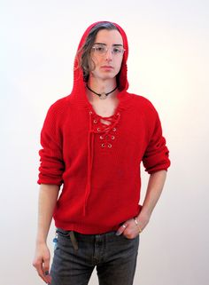 This is a vibrant Y2K vintage red knit hoodie sweater! It's knit with a soft bright red yarn and has a deep V neck in the front that laces up through large silver grommets. This oversized hooded pullover has long sleeves and a generously relaxed fit, and is a lightweight sweater, making it great for a cool spring or fall day. The hood is slightly pointed in the back and has no drawstring or laces. This garment is in very good, freshly laundered, clean condition with no flaws or wear noted. There's no maker's label, the care tag reads "100% Chemical Fiber, Hand Wash Cold, Line Dry, L." The "chemical fiber" refers to it being knit with a polymer acrylic yarn. It's meant to be a slouchy oversized Large and it fits like a Unisex Large to XL. It measures: Chest - 50 inches, Waist - 40 inches, S Hooded Knitted Sweater For Streetwear, Knitted Hooded Sweater For Streetwear, Red Sweater For Fall Streetwear, Red Hoodie Sweater For Winter, Knitted Hooded Hoodie For Streetwear, Knitted Hoodie For Streetwear, Red Winter Hoodie Sweater, Red Hooded Sweater For Fall, Red Hooded Fall Sweater