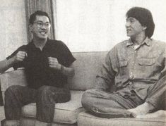 two men sitting on a couch with their fists up