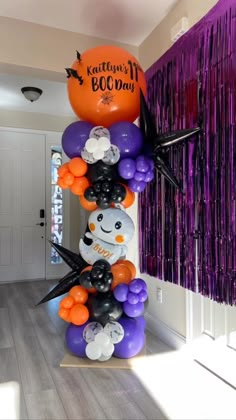 the balloon column is decorated with halloween decorations and balloons, including a snowman on top