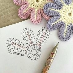 a crochet pattern and pen sitting on top of a piece of paper