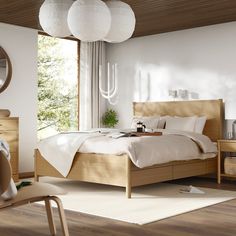 a bed room with a neatly made bed next to a chair and table in front of a window