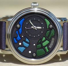 a close up of a watch on a table with a clock face in the middle