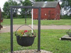 a hanging planter filled with flowers in front of a red barn