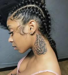 a woman with braids has a tattoo on her neck