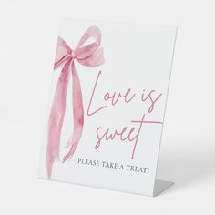 a card with the words love is sweet on it and a pink bow tied around it