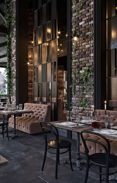 an empty restaurant with tables and chairs in front of a brick wall that has ivy growing on it