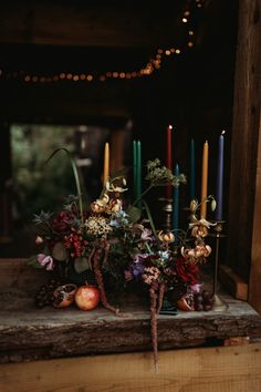 an arrangement of flowers and candles on a table