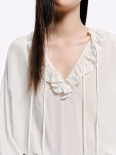 MO&Co. Women's Loose Ruffled Trim Blouse Crafted from a blend of cotton and silk, this blouse features billowy sleeves with delicate ruffled cuffs and a V-neckline with a self-tie design. The loose silhouette pairs perfectly with high-waisted jeans for a chic, effortless look. Features : - Flowy regular fit- Volume sleeves with ruffled cuffs- V neckline with self-tie straps and ruffles details- Made a silk and cotton fabric, slightly sheer effect Code: MBD1TOP026The back length of size S is 68.5cmMATERIALS & CARE Material: 63.9% Cotton 36.1% SilkREMINDER: All items are measured manually. Please note that it's reasonable that there might be minor measurement differences (1-2cm) on some items.