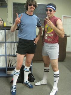 two men standing next to each other in shorts