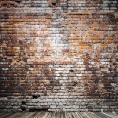 an old brick wall with wood flooring in the foreground and light colored paint on it