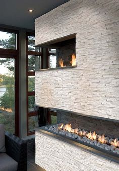 a fire place in the middle of a living room next to a couch and window