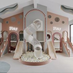 an indoor play area with slides and rocks in the center, surrounded by pink walls