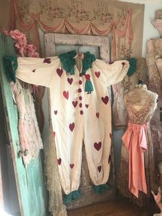 an old fashioned baby's clothing is hanging on the wall