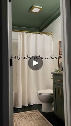 a bathroom with a white shower curtain and rug on the floor in front of it