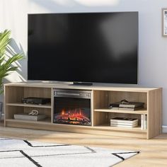 a flat screen tv sitting on top of a wooden entertainment center next to a fire place