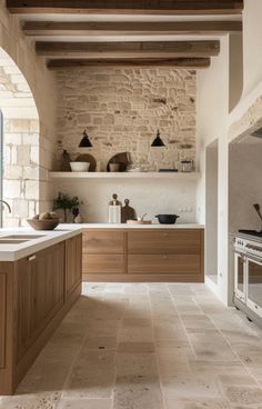 a kitchen with stone walls and flooring next to a stove top oven in a room