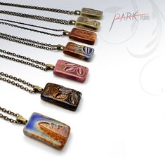 six necklaces with different designs on them, all in different colors and sizes are shown