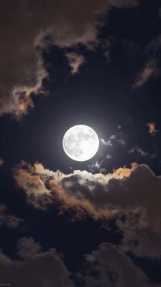 the full moon is seen through some clouds