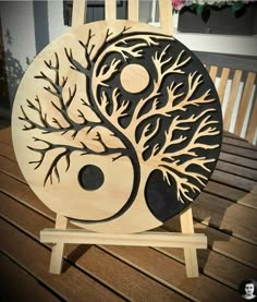 a wooden sign with a tree and yin - yang symbol on it's side