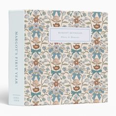 a blue and white book with an ornate pattern on the front, featuring flowers and leaves