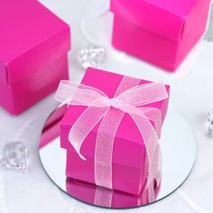 a pink gift box sitting on top of a white plate next to some crystal beads