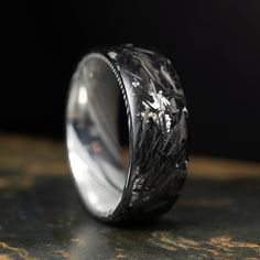 the wedding band is made out of silver and black marble