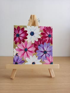 an easel with a painting on it sitting on a table