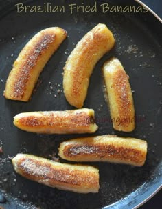 fried bananas in a frying pan with sugar on top