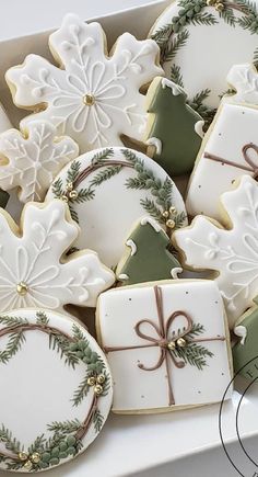 decorated christmas cookies in a white box with green and gold trimmings on them