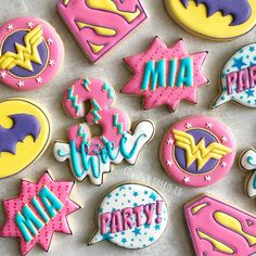 some decorated cookies are laying out on a table with the words super hero written in them