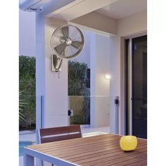 a table with a fan hanging from it's side next to a patio area