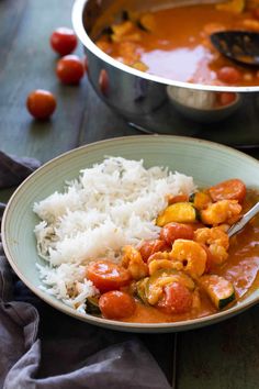 a bowl filled with rice and shrimp next to a pot of tomato sauce on a table