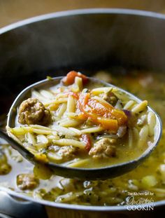 a spoon full of soup with meat and vegetables